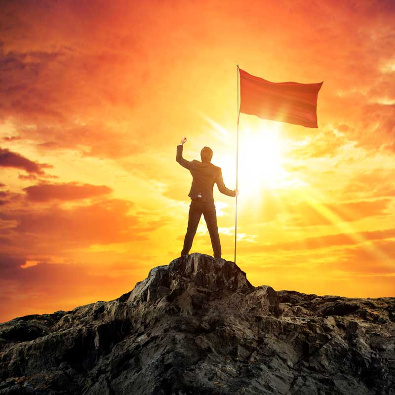 businessman-with-flag-mountain-top businessman-with-flag-mountain-top