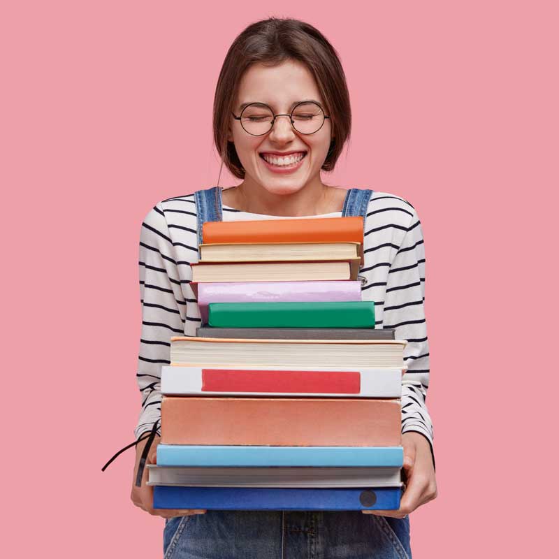 photo-pleased-teenage-girl-holds-heap-textbooks-being-high-spirit-wears-denim-overalls-poses-against-pink-background photo-pleased-teenage-girl-holds-heap-textbooks-being-high-spirit-wears-denim-overalls-poses-against-pink-background